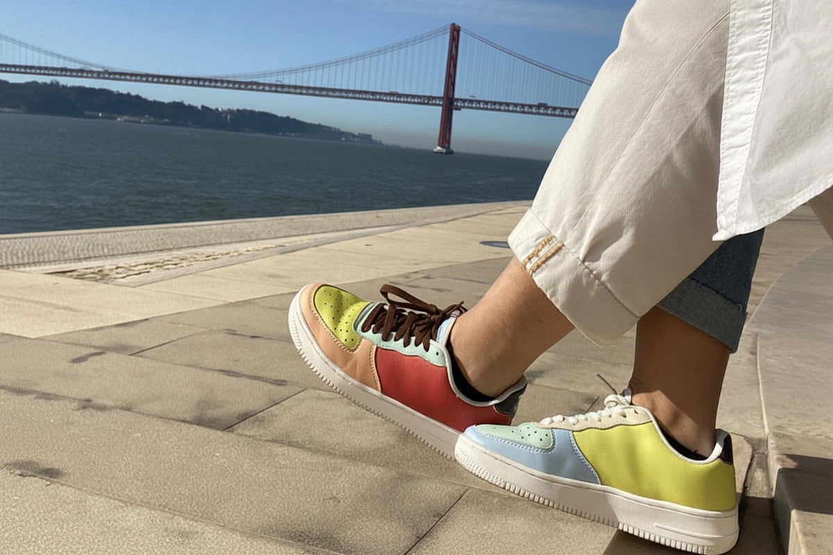 Person wearing colorful sneakers with a bridge and water in the background